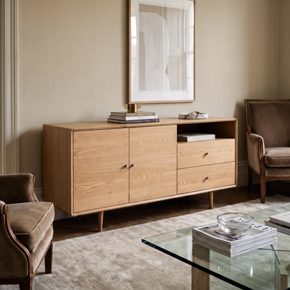 Rowan Large Oak Sideboard styled in a minimalist living room with a neutral rug, velvet armchairs, and a glass coffee table.